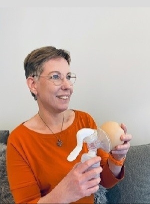 imetysohjaus. Titta järvenpää näyttää miten rintapumppu toimii. Tekorintaa apuna käyttäen .Istuu sohvalla hymyillen.